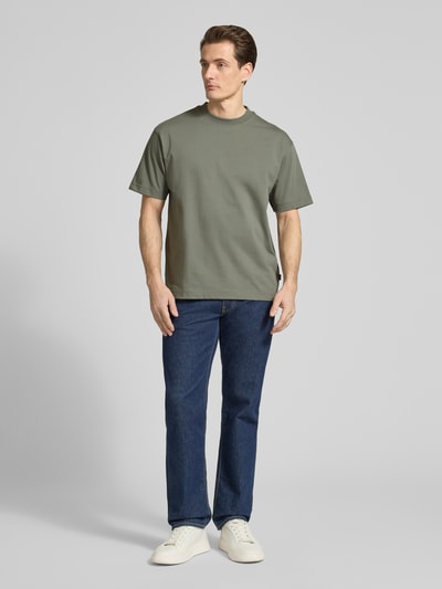 Männermodel trägt Regular Fit T-Shirt aus reiner Baumwolle Modell 'TEETIMM' von BOSS Orange in Khaki, unifarben, Ganzkörperansicht von vorne.