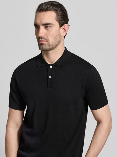 Männermodel trägt Regular Fit Poloshirt in Strick-Optik von Christian Berg Men in Schwarz, reine Baumwolle, Kurzärmelig, Nahaufnahme Oberkörper.
