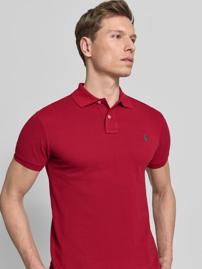 Männermodel trägt Slim Fit Poloshirt aus reine katoen van Polo Ralph Lauren, look: effen, gestikt logo, polokraag, 2-knoopsluiting, korte mouw, rompzoom met split, piqué, nahaufnahme bovenlichaam.
