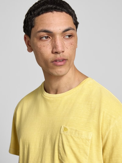 Männermodel trägt T-Shirt aus Baumwoll-Leinen-Mix mit Brusttasche von Superdry in Gelb, Rundhalsausschnitt, Regular-Fit, Nahaufnahme Oberkörper, Rückenlänge bei Größe M 66 cm.