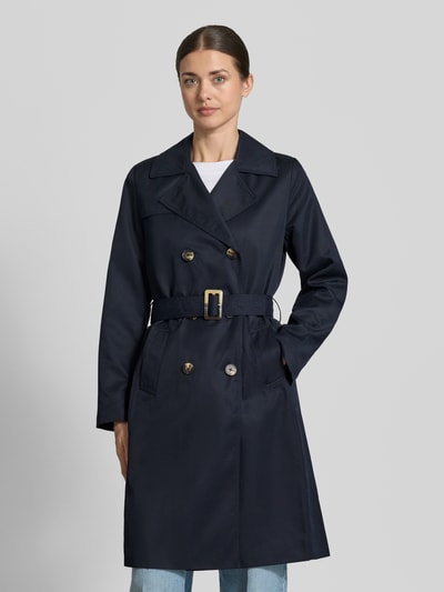Frauenmodel trägt Trenchcoat mit Gürtel und seitlichen Eingrifftaschen von Zero, taillierter Schnitt, Reverskragen, Doppelreiher, Ganzkörperansicht von vorne.