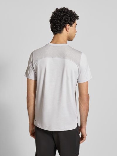 Männermodel trägt Regular Fit T-Shirt mit Rundhalsausschnitt von PUMA PERFORMANCE, Baumwoll-Viskose-Mix, Rückenansicht, Rückenlänge 51 cm, Ärmellänge 70 cm, schlichter Look mit Logo-Print, helle Grautöne und glatte Textur. Ganzkörperansicht Rückansicht.