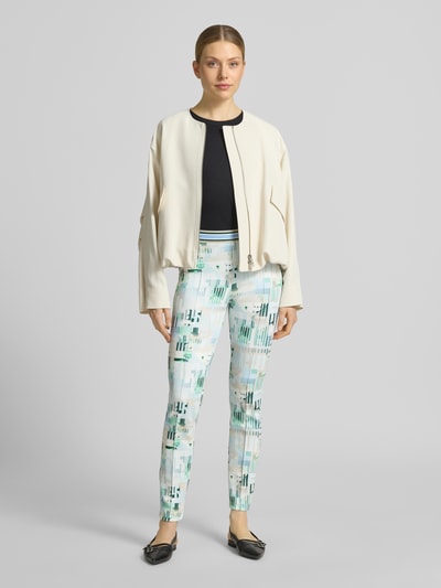 Frauenmodel trägt Slim Fit Leggings mit elastischem Bund von Marc Cain aus Elastischer-Material-Mix mit Allover-Statement-Print, Ganzkörperansicht von vorne.