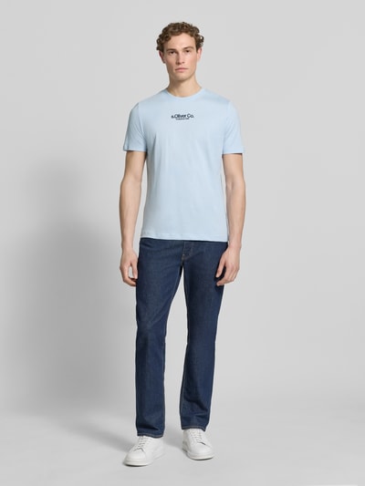Męski model nosi Regular Fit T-Shirt aus reiner Baumwolle von s.Oliver RED LABEL, jednolity kolor, nadruk z logo, okrągły dekolt, krótki rękaw, bawełna, Ganzkörperansicht von vorne.