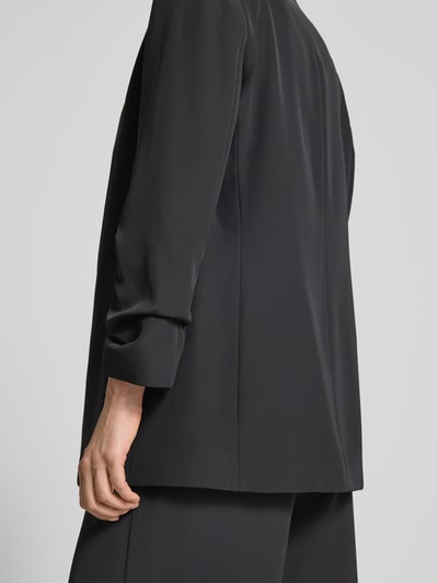 Frauenmodel trägt Relaxed Fit Blazer mit Pattentaschen von Jake*s Collection, Material-Mix mit Stretch, schwarze Farbe, Detailaufnahme Rückansicht.