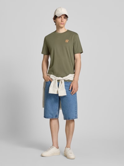 Männermodel trägt T-Shirt mit Stitching Modell 'KAAN' von Blend, reine Baumwolle, Regular Fit, olivgrün, Ganzkörperansicht von vorne.