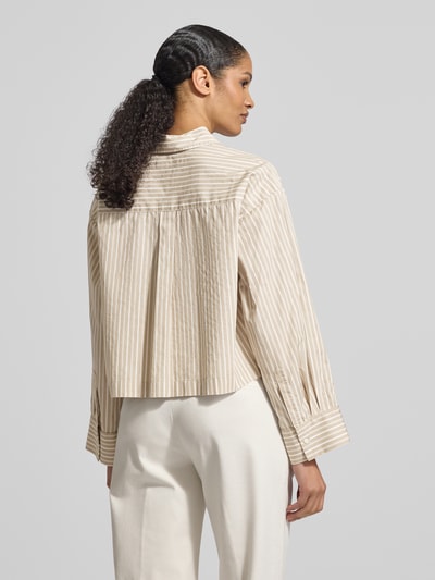 Vrouwenmodel draagt Oversized Hemdbluse aus reiner Bio-Baumwolle Modell 'Astha' van Selected Femme, look: effen, oversized fit, overhemdkraag, achterpas met plooien, mouwboord met manchet, borstzak, webstof, biologisch katoen. Ganzkörperansicht Rückansicht.