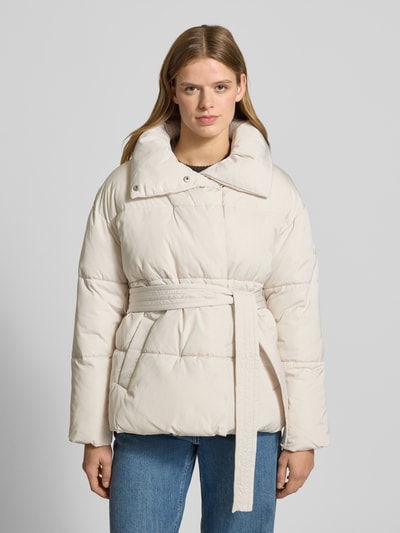 Frauenmodel trägt Steppjacke mit Bindegürtel Modell 'Margitta' von LeGer by Lena Gercke in Beige, Regular Fit, Stehkragen, Eingrifftaschen, Ganzkörperansicht von vorne. Rückenlänge 70 cm, Schulterbreite 57 cm, Brustweite 58 cm, Ärmellänge 55 cm bei Größe 36.