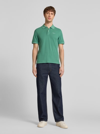 Männermodel trägt Regular Fit Poloshirt aus reiner Baumwolle Modell 'OSCAR' von Pepe Jeans, Optik: Unifarben, Ganzkörperansicht von vorne.