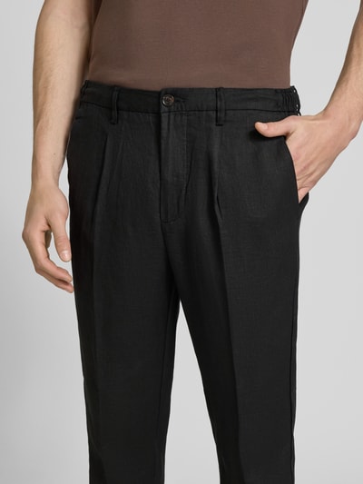 Männermodel trägt Hose mit Gesäßtaschen Modell 'PANTALACCIO LINO' von MARKUP aus Reiner Baumwolle, schwarze Textur, Regular-Fit, Nahaufnahme Oberkörper, Bundweite bei Größe 50: 44 cm, Innenbeinlänge: 71 cm.