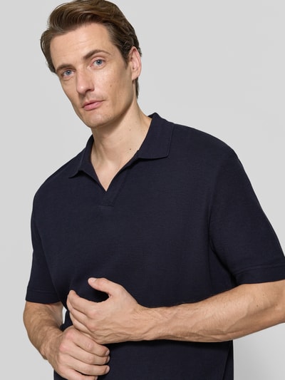 Männermodel trägt Regular Fit T-Shirt aus reiner Baumwolle von Marc O'Polo in Dunkelblau mit glatter Textur, Nahaufnahme Oberkörper.
