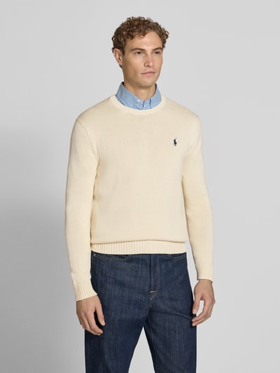 Männermodel trägt Relaxed Fit Pullover aus reiner Baumwolle von Polo Ralph Lauren in Beige, strukturierte Oberfläche, Ganzkörperansicht von vorne. Herren Pullover von Polo Ralph Lauren.
