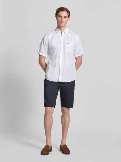 Männermodel trägt Slim Fit Freizeithemd aus Leinen-Baumwoll-Mix von Fynch-Hatton in Weiß, Knopfleiste, Brusttasche, Ganzkörperansicht von vorne