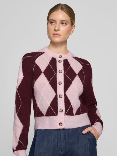 Modelka kobieca nosi Cardigan aus Woll-Mix mit Rundhalsausschnitt Modell 'JOHI' od YAS, bordowo-różowe romby, prosta faktura, zbliżenie na górną część ciała.