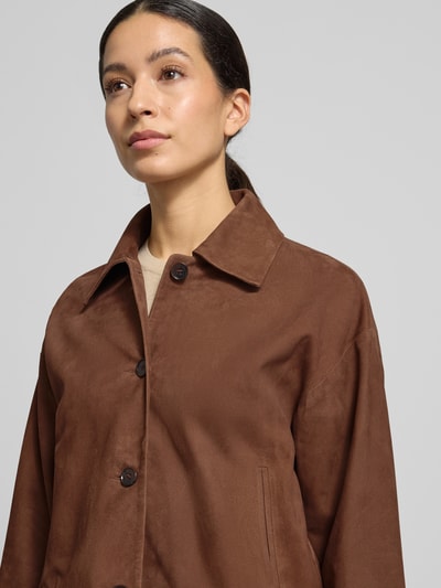 Modelka nosi Regular Fit Jacke aus echtem Lammvelours mit Umlegekragen od Windsor, brązowy kolor, miękka tekstura, zamek na guziki, kieszenie na dłonie, krój regular fit, widok z przodu, zbliżenie na górną część ciała