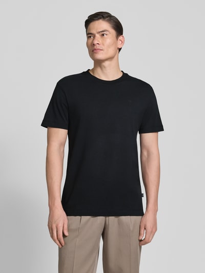 Männermodel trägt T-Shirt mit Rundhalsausschnitt Modell 'Carlonito' von JOOP! Collection, schwarz, Straight Fit, Baumwoll-Mix, Ganzkörperansicht von vorne.