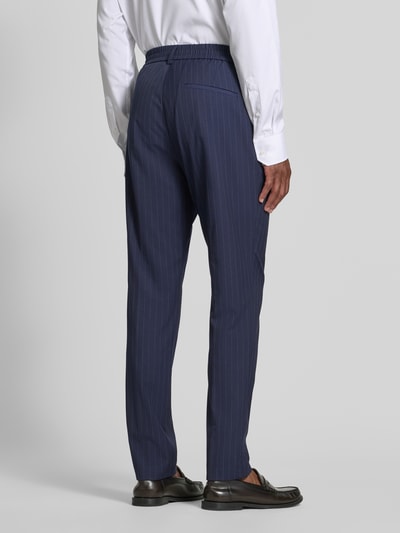 Männermodel trägt Wide Leg Anzughose mit Viskose-Anteil von s.Oliver BLACK LABEL in Dunkelblau mit feiner Nadelstreifenstruktur, Ganzkörperansicht Rückansicht.