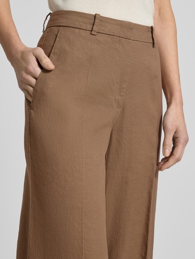 Frauenmodel trägt Hose aus Leinen-Mix mit Bügelfalten Modell 'MIRA' von Cambio in Braun, Regular-Fit, Nahaufnahme Oberkörper. Damen Hose mit Baumwoll-Anteil, strukturierte Oberfläche, Bundweite 38 cm, Innenbeinlänge 85 cm, Größe 36.