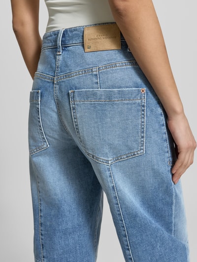 Frauenmodel trägt Straight Fit Jeans mit aufgesetzten Taschen Modell 'Ocean' von Cambio aus Baumwoll-Mix, mittleres Blau, Nahaufnahme Rückansicht. Bundweite 42 cm, Innenbeinlänge 72 cm, Knopf- und Reißverschluss, sichtbare Gesäßtaschen.