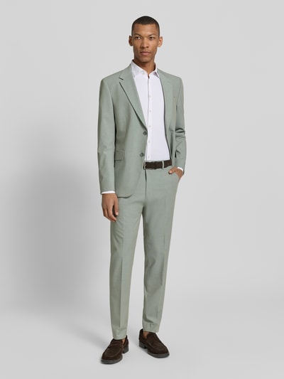Męski model nosi Slim Fit Anzugsakko mit Pattentaschen Modell 'AIDAN3' od Strellson w optyce melange, z dwoma rozcięciami z tyłu, z długimi rękawami, ozdobnymi guzikami przy mankietach, kieszenią na piersi i klapowanymi kieszeniami, z dwurzędowym zapięciem na dwa guziki, z kołnierzem z klapami, krój slim fit; jasnoszary odcień, gładka tekstura, pełny widok z przodu.