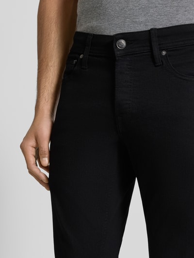 Männermodel trägt Stoffhose mit Gesäßtaschen Modell 'GLENN' von JACK & JONES aus Baumwoll-Mix mit Stretch-Anteil, Nahaufnahme Hüfte.