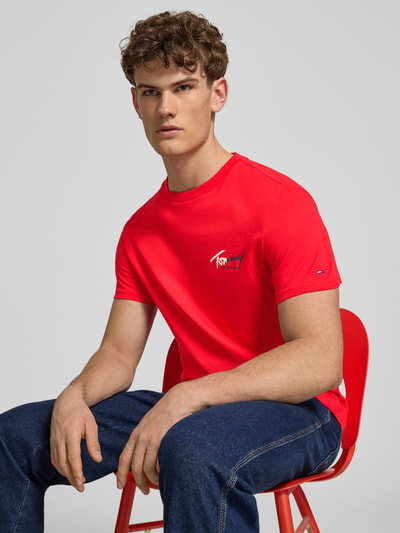 Männermodel trägt Regular Fit T-shirt aus puur katoen van Tommy Jeans in look: effen kleuren met labelprint en gestikt logo, korte mouw, ronde hals, jersey materiaalverwerking, Ganzkörperansicht von vorne.