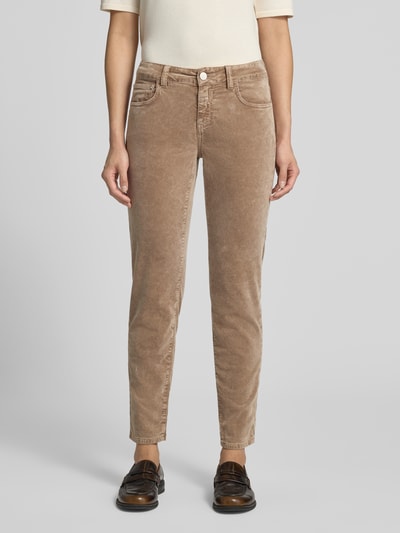 Frauenmodel trägt Slim Fit Jeans aus Baumwoll-Mix Modell 'Baker' von Closed in Beige mit 5-Pocket-Design, Ganzkörperansicht von vorne. Elastischer Baumwoll-Mix, verkürzte Passform, Logo-Patch, Knopf- und Reißverschluss.