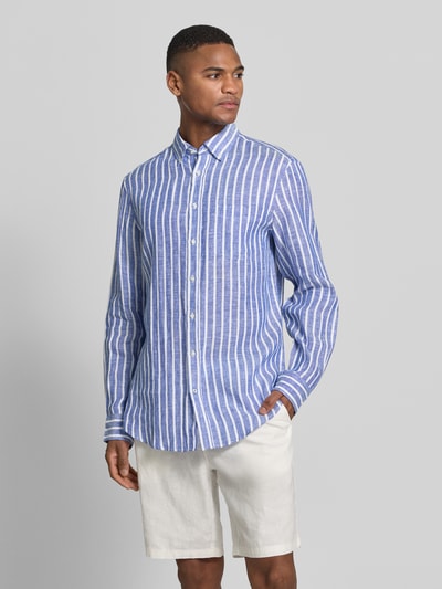 Męskimodel nosi Slim Fit Freizeithemd aus reinen Leinen von Christian Berg Men, niebiesko-białe pionowe paski, kołnierzyk typu button down, krój slim fit, listwa guzikowa, z długim rękawem, sportowe mankiety, długość tyłu w rozmiarze M: 79 cm, szerokość ramion w rozmiarze M: 48 cm, długość rękawów w rozmiarze M: 65 cm; całkowity widok z przodu.