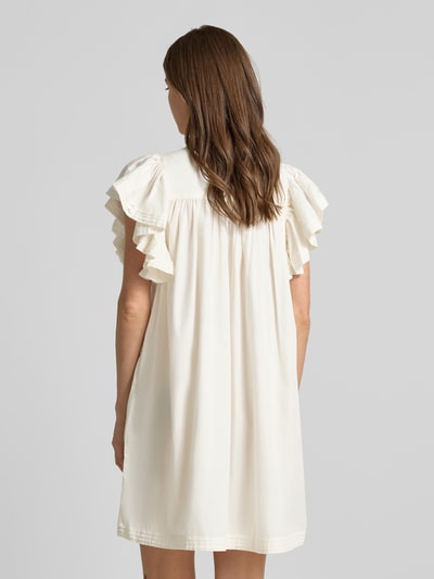 Frauenmodel trägt Minikleid mit Schmetterlingsärmel Modell 'LURA' von YAS im Material-Mix mit Baumwoll-Anteil, Straight Fit, Rückenlänge 88 cm, Cremefarbe, fließende Struktur, Ganzkörperansicht Rückansicht.