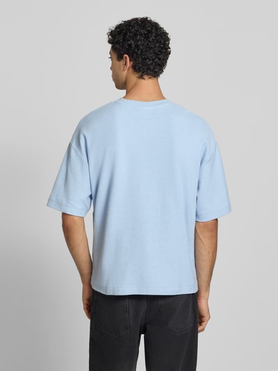 Männermodel trägt T-Shirt mit Rundhalsausschnitt und Label-Stitching von REVIEW in Hellblau, Baumwoll-Mix, Relaxed-Fit, Rückenlänge 64 cm, Ganzkörperansicht Rückansicht.