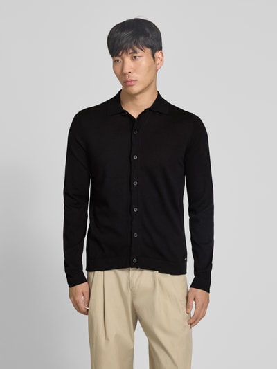 Männermodel trägt Strickjacke mit Polokragen Modell 'CAMICIA IN MAGLIA' von MARKUP, Reine Baumwolle, Slim-Fit, schwarze Farbe, Ganzkörperansicht von vorne.