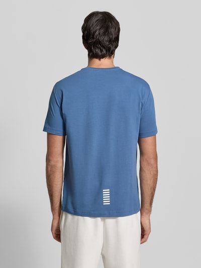 Männermodel trägt Regular Fit T-Shirt mit Logo-Print von EA7 Emporio Armani aus elastischem Baumwoll-Mix, Rückenlänge 66 cm, Ganzkörperansicht Rückansicht.