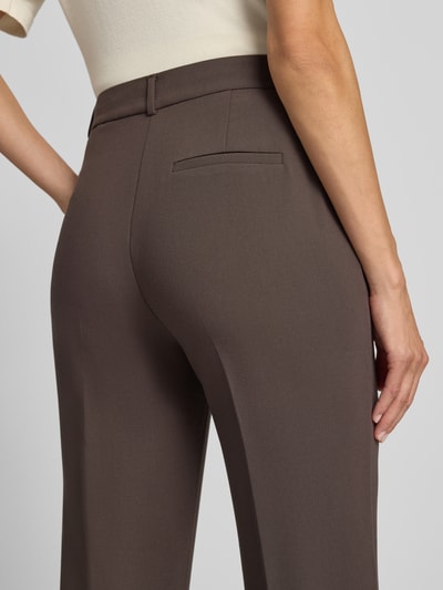 Frauenmodel trägt Straight Fit Hose mit Viskose-Anteil von COMMA in Braun, glatte Textur, dezente Bügelfalte, Detailaufnahme Rückansicht, elastischer Material-Mix
