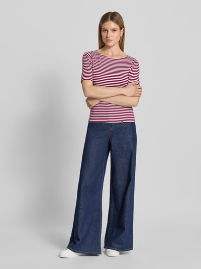 Frauenmodel trägt T-Shirt mit U-Boot-Ausschnitt und Label-Detail von Zero, Damen T-Shirt im Baumwoll-Mix mit Stretch-Anteil, Gerader-Schnitt, 3/4-Arm, Rückenlänge 56 cm bei Größe 36, Querstreifen in Rosa und Dunkelblau, kombiniert mit weiter Jeans, Ganzkörperansicht von vorne.