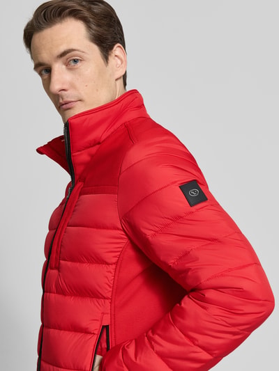 Männermodel trägt Regular Fit Steppjacke mit seitlichen Stretcheinsätzen von Tom Tailor, Optik: Unifarben, Logo-Patch, Nahaufnahme Oberkörper.