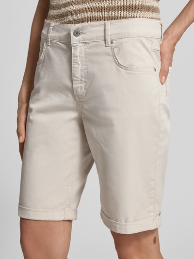 Frauenmodel trägt Bermudas mit Umschlag und Eingrifftaschen von Angels, Regular-Fit, beige, Knopf-Reißverschluss, Nahaufnahme Oberkörper. Bundweite bei Größe 36: 40 cm, Innenbeinlänge bei Größe 36: 25 cm.