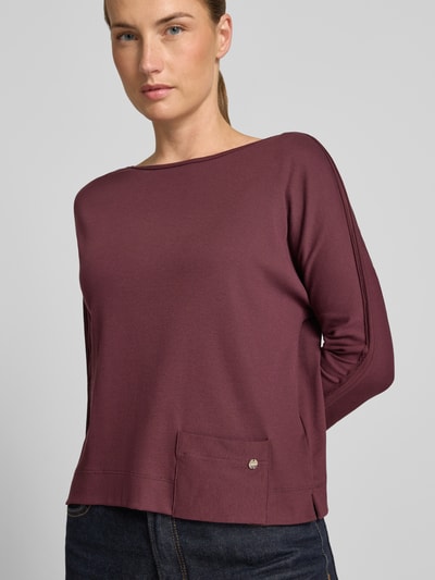 Modelka nosi damski t-shirt z mieszanki bawełny i elastanu, krój regular fit, okrągły dekolt, rękaw o dł. 3/4, długość tyłu 52 cm w rozmiarze 36, T-Shirt mit 3/4-Arm od Marc Cain, widok na górną połowę ciała z przodu.