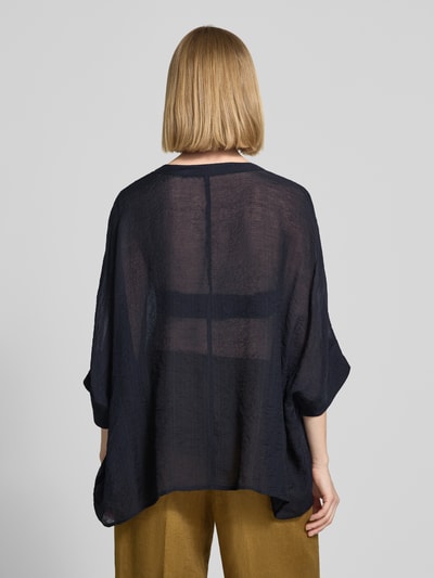 Frauenmodel trägt Relaxed Fit Bluse aus Viskose-Mix mit V-Ausschnitt von Comma in dunklem Blau, leichte transparente Textur, 3/4-Arm, Rückenlänge 62 cm, Ärmellänge 7 cm, Ganzkörperansicht Rückansicht.