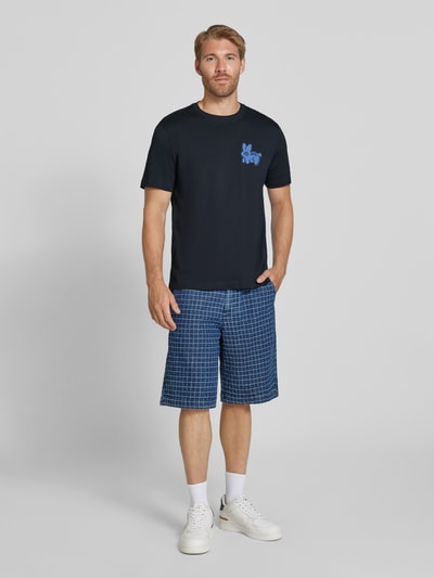 Männermodel trägt Regular Fit T-Shirt aus reiner Baumwolle von Paul Smith, dunkelblau mit blauem Statement-Print, Ganzkörperansicht von vorne. Herren T-Shirt, Rundhalsausschnitt, Rückenlänge bei Größe M: 64 cm.