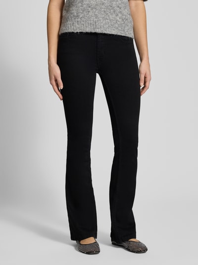 Frauenmodel trägt Flared Jeans mit mittelhohem Bund von Review, schwarze Waschung, 5-Pocket-Design, Nahaufnahme Unterkörper.