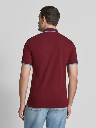 Männermodel trägt bordeauxrotes Slim-Fit Poloshirt aus Baumwoll-Mix Modell 'ATLAS' von Selected Homme, Herren, Ganzkörperansicht Rückansicht.