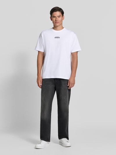 Männermodel trägt wit regular fit t-shirt van puur katoen Model 'Oliver' van Wood Wood, gestikt logo, ruglengte maat M 73 cm, ganzlichaamsvoorzijde.