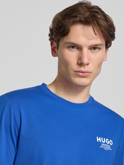 Męski model nosi Regular Fit T-Shirt aus reiner Baumwolle Modell 'NESPTEE' od HUGO w kolorze niebieskim, męski t-shirt HUGO Blue, zbliżenie na górną część ciała