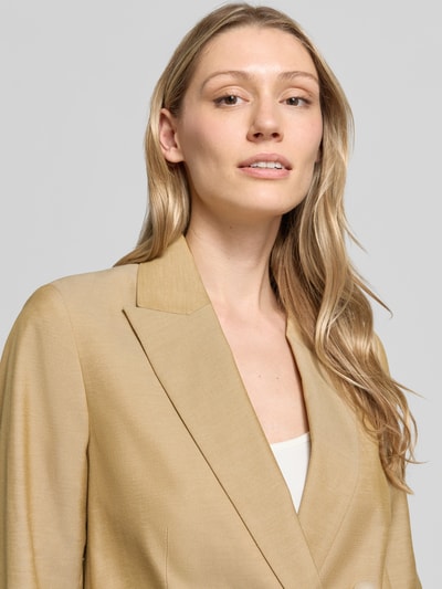 Frauenmodel trägt Blazer mit Leinen-Anteil und Pattentaschen von Comma, Material-Mix, Reverskragen, beige, Nahaufnahme Oberkörper.