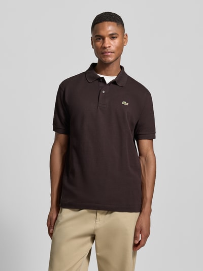 Männermodel trägt Regular Fit Poloshirt aus reiner Baumwolle von Lacoste, unifarben, kurzarm, Logo-Stitching, Vorderansicht Oberkörper.