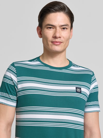 Männermodel trägt T-Shirt mit Label-Patch und Rundhalsausschnitt von Lerros, grün-weiß gestreift, Reine Baumwolle, Regular-Fit, Nahaufnahme Oberkörper. Rückenlänge bei Größe M 72 cm.