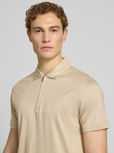 Männermodel trägt Regular Fit Poloshirt aus Lyocell-Baumwoll-Mix Modell 'H-PARAS 50' von BOSS in Beige, unifarben, Nahaufnahme Oberkörper.
