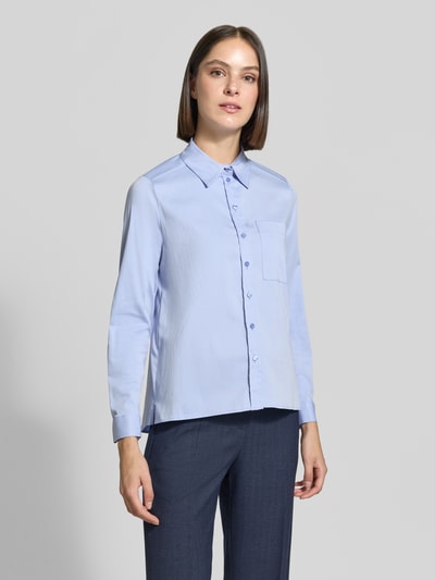 Frauenmodel trägt Regular Fit Hemdbluse aus Baumwoll-Mix von Milano Italy, hellblau, Hemdblusenkragen, Brusttasche, Ganzkörperansicht von vorne. Rückenlänge 66 cm, Ärmellänge 60 cm, elastischer Stoff, verlängerte Rückseite.