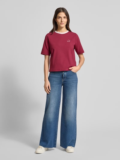 Vrouwenmodel draagt Regular Fit T-shirt met strass-steentjes van Marc Cain, elastische mix van katoen en modal, ronde hals, Ganzkörperansicht von voren.
