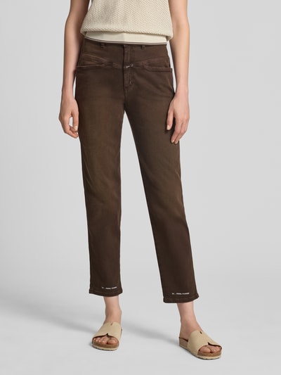 Kobiece modelka nosi brązowe jeansy Relaxed Fit Jeans mit Label-Detail Model 'PEDAL PUSHER' od Closed z mieszanki bawełny z dodatkiem streczu, wpuszczane kieszenie, detal z logo; szerokość w rozmiarze 27/32: 36 cm, długość wewnętrzna nogawki: 70 cm. Ganzkörperansicht von vorne.